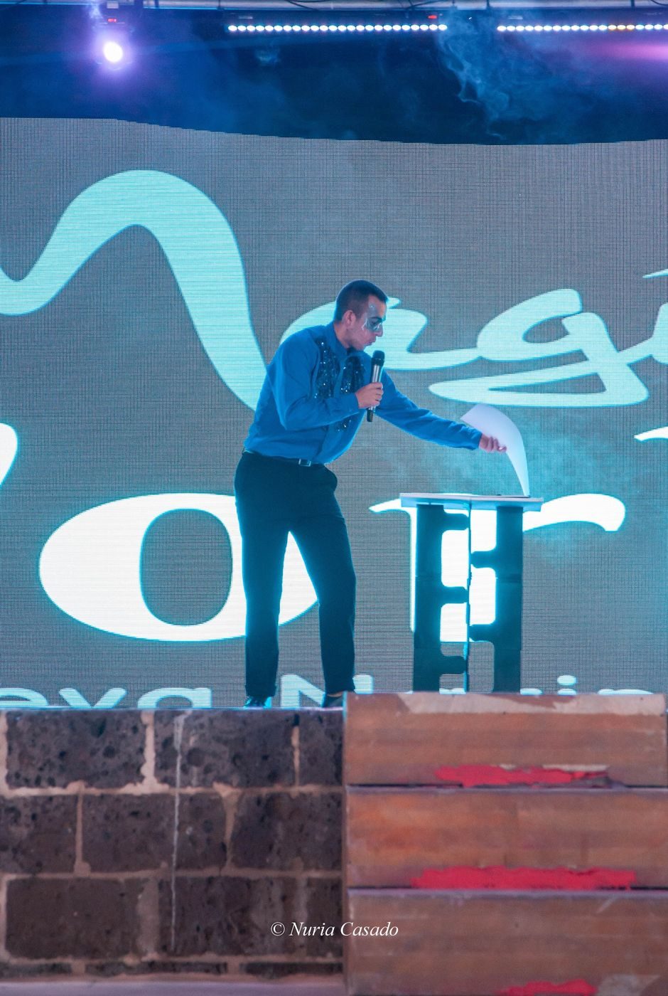 Raúl Fernández actuando como mentalista sobre un gran escenario en un evento