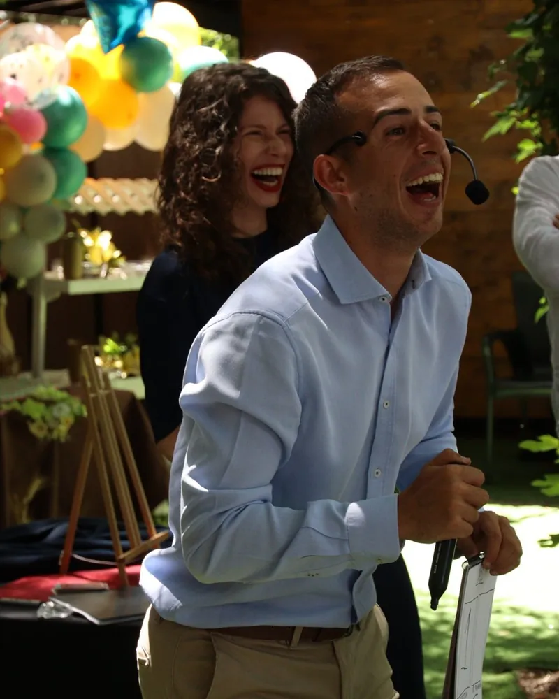 Magic Raulin riendo con los invitados en una fiesta familiar con globos